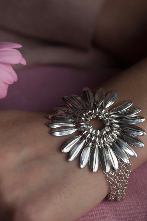My Gerbera Bracelet worn in silver features a large stylised gerbera flower with movable petal charms 