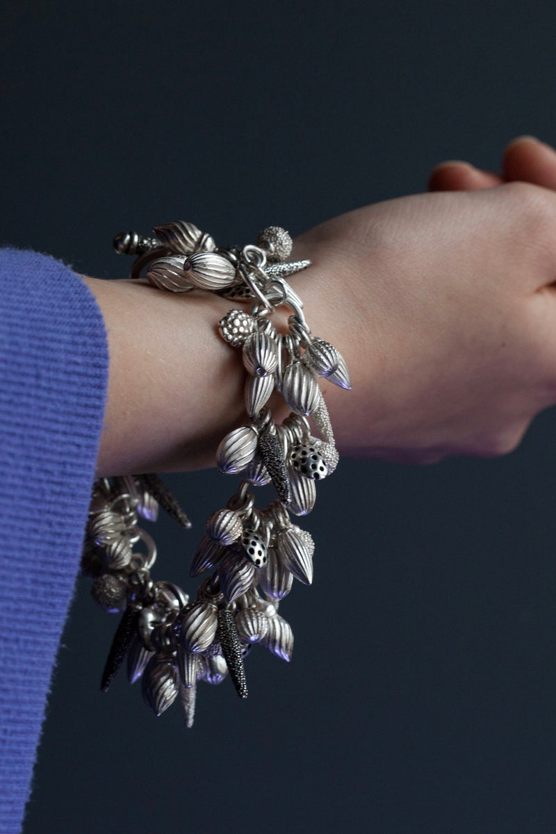 My Mixed Pod Cluster Bracelet worn by a model hangs with lots of charms inspired by seed pods