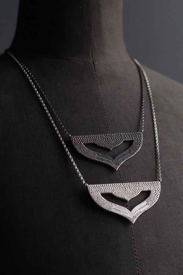 A pair of my Astral Pendant Necklaces, inspired by Asian warrior helmets and the necklace I created for the Star Wars film, Solo. This stylish pendant features my signature texture to catch the light and can be worn at two lengths.