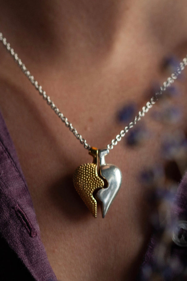 Chunky heart shaped pendant worn in silver and gold plated silverin two separate halves that together make one
