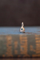 A delicate swirling gemstone charm – choose a blue Topaz for your November birthday. 