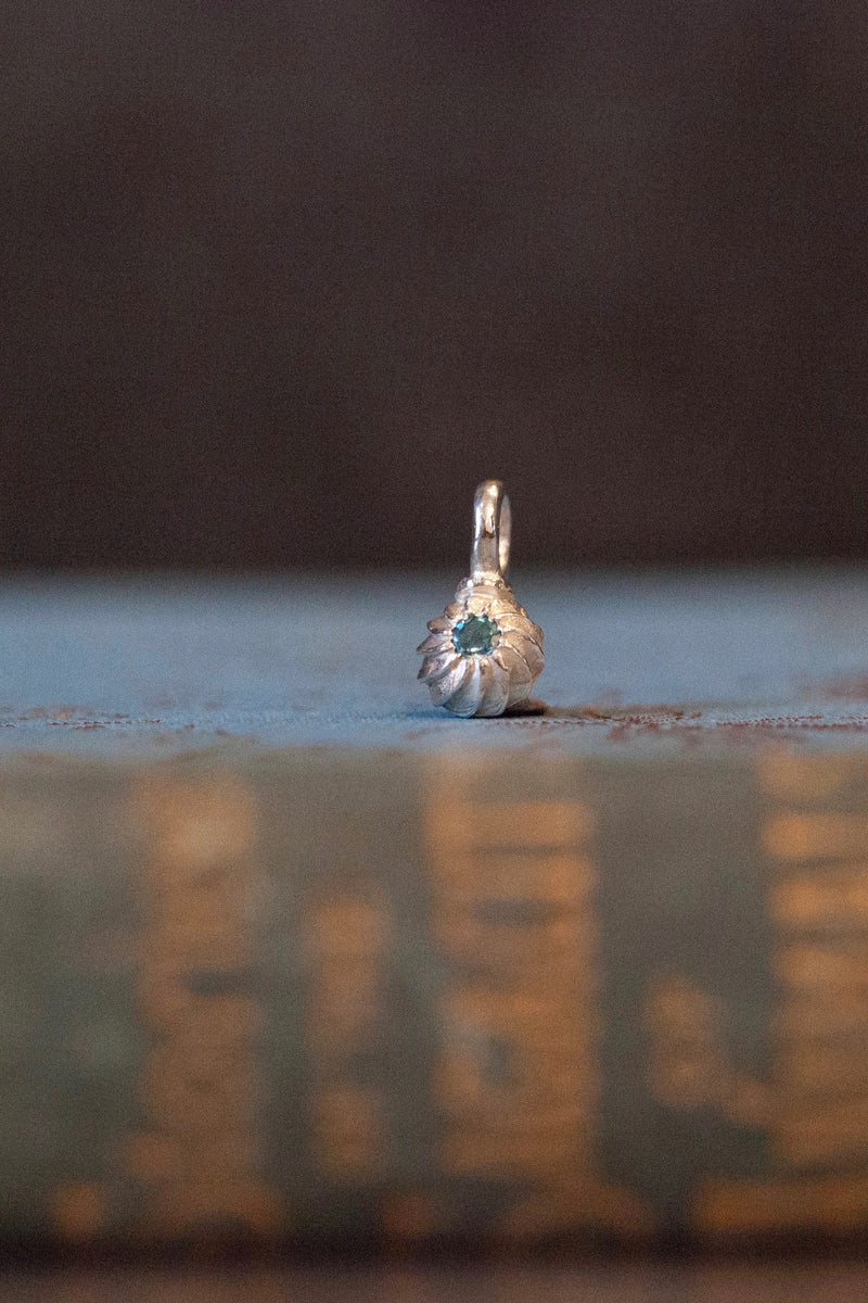 A delicate swirling gemstone charm – choose a blue Topaz for your November birthday. 