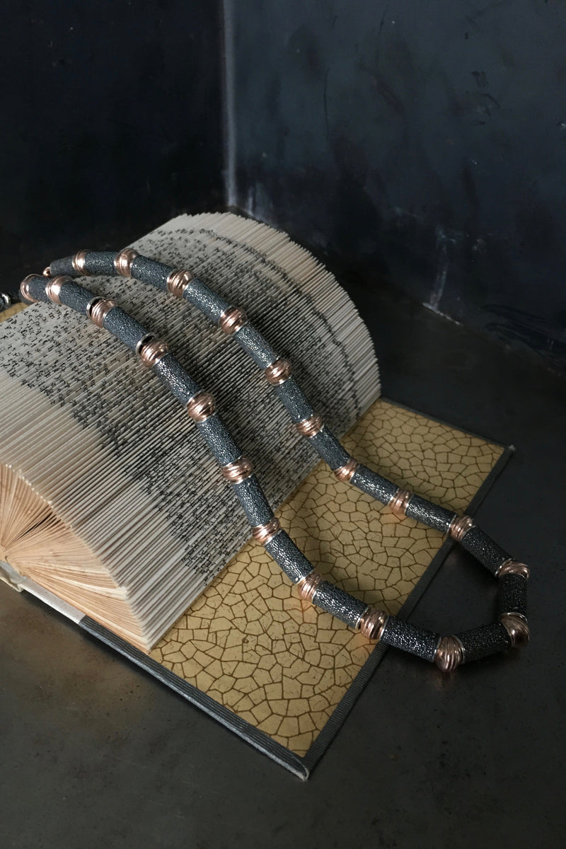 Necklace with textured silver beads alternating with striped round beads in contrasting metals