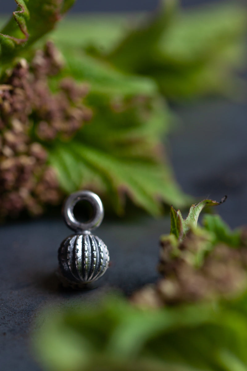 My Round Pod Charm is ball shaped with a striped texture inspired by flax seed pods
