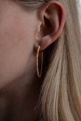 My Elliptical Hoop Earrings worn by a model in yellow gold plated silver