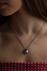 This little ladybird charm pendant worn by a modelhas articulated wings and tiny legs on the back