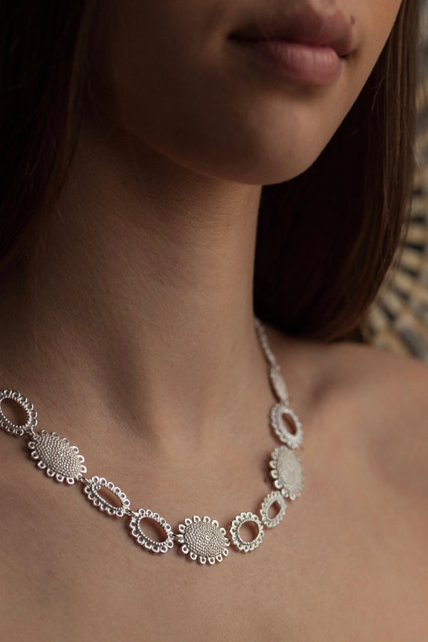 My Baroque Necklace, worn by a model, features 24 highly decorated oval motifs, inspired by antique lace, and is designed to add drama to any outfit with its ornate detail.