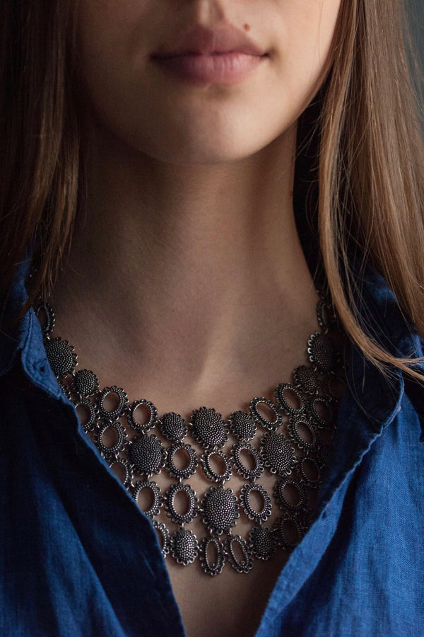 My Baroque Armour Necklace worn by a model inside a blue shirt, was inspired by antique lace and ruffs 