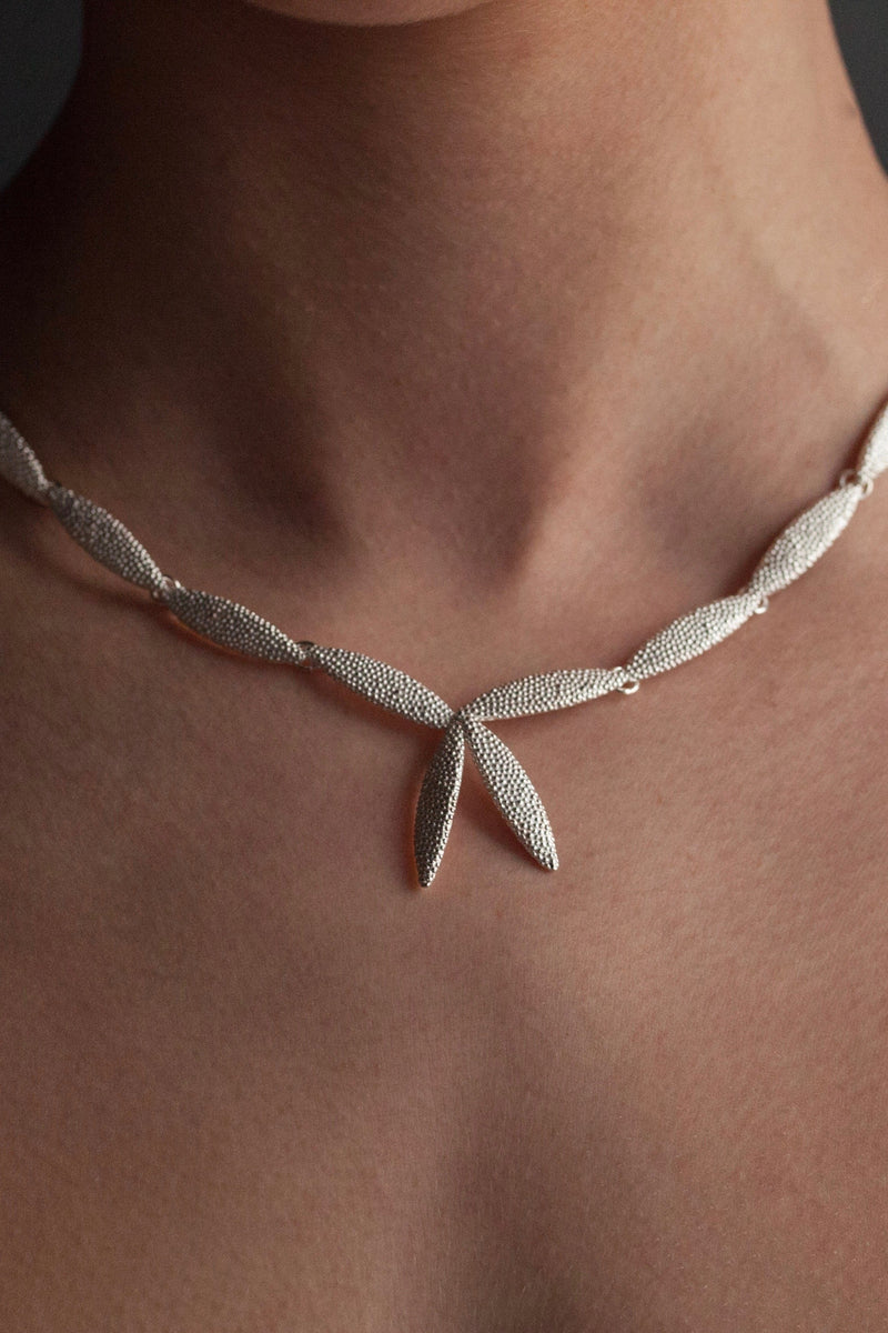 My Petal Necklace worn in silver links textured petals into a chain with two petals as a focal point