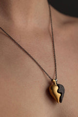 Chunky heart shaped pendant worn in gold plated and oxidised silver has two separate halves that together make one
