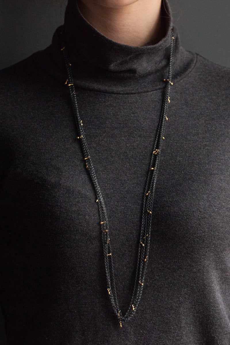 My Five Strand Trace and Pip Necklace worn long comprises five delicate oxidised silver chains, decorated with miniature gold plated pips