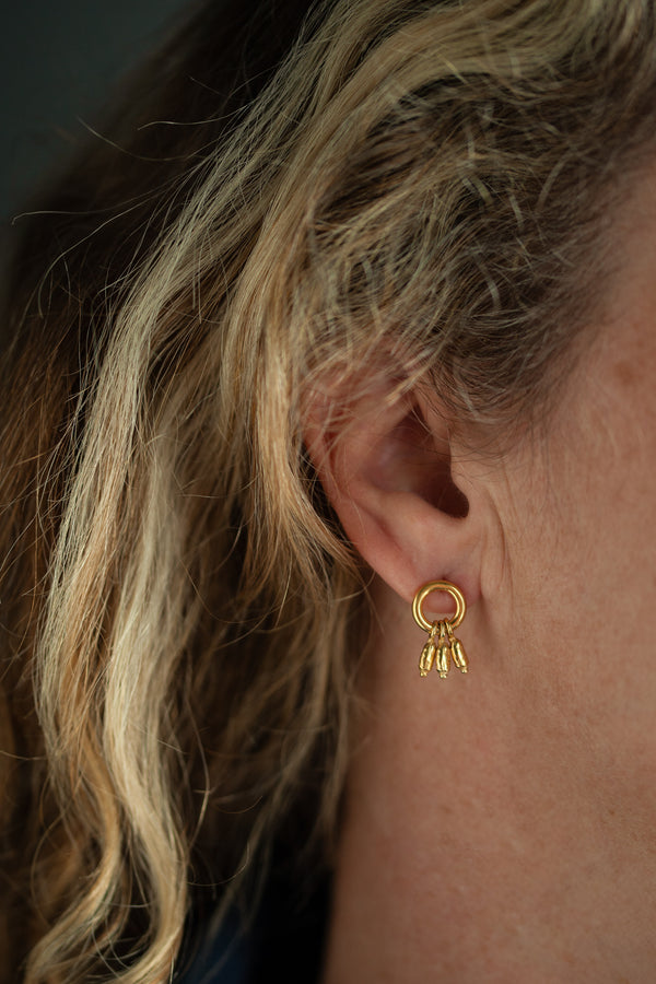 Small circular hoops finished with three charms inspired by rice pearls.