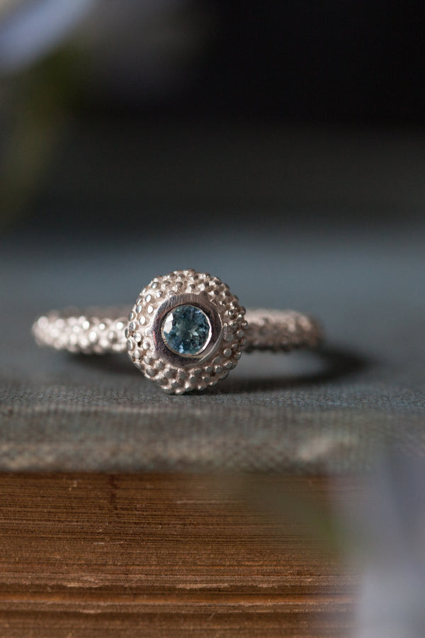 My March Aquamarine Bobbled Pollen Stacking Ring has a bobble textured disc set with an aquamarine gemstone