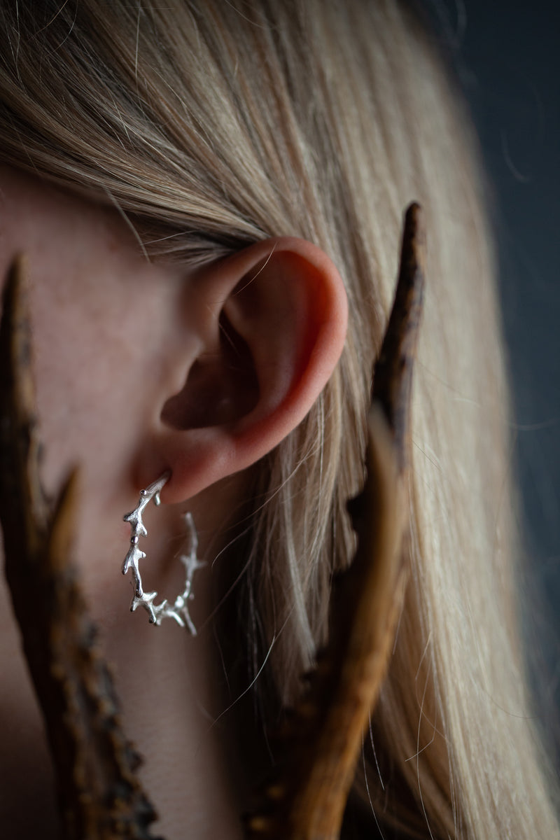 Antler earrings worn with a curve like antlers