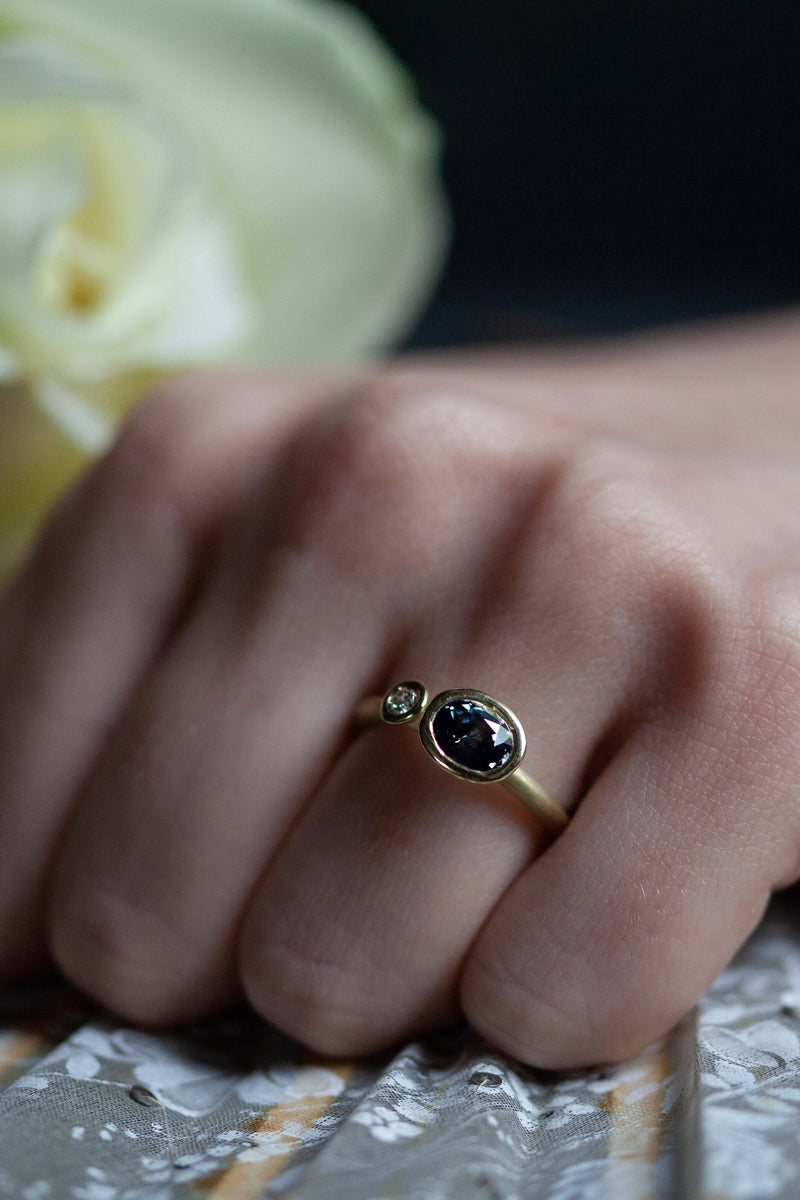 A one off Blue Spinel in 18ct yellow gold cup setting with a white diamond on 18ct yellow gold band 