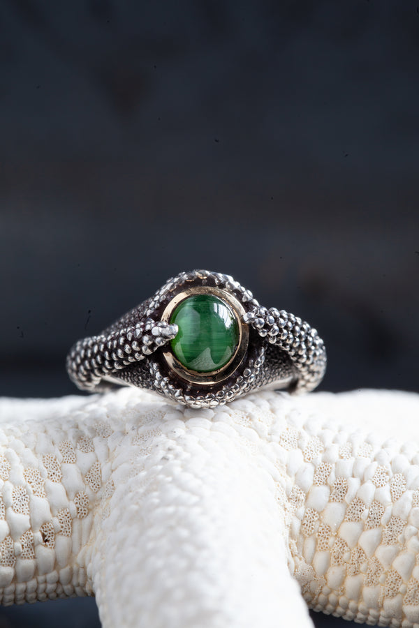 The centrepiece of this ring is an incredible green Cat's Eye Tourmaline, set in 9ct yellow gold and housed in a textured blacked oxidised silver ring.