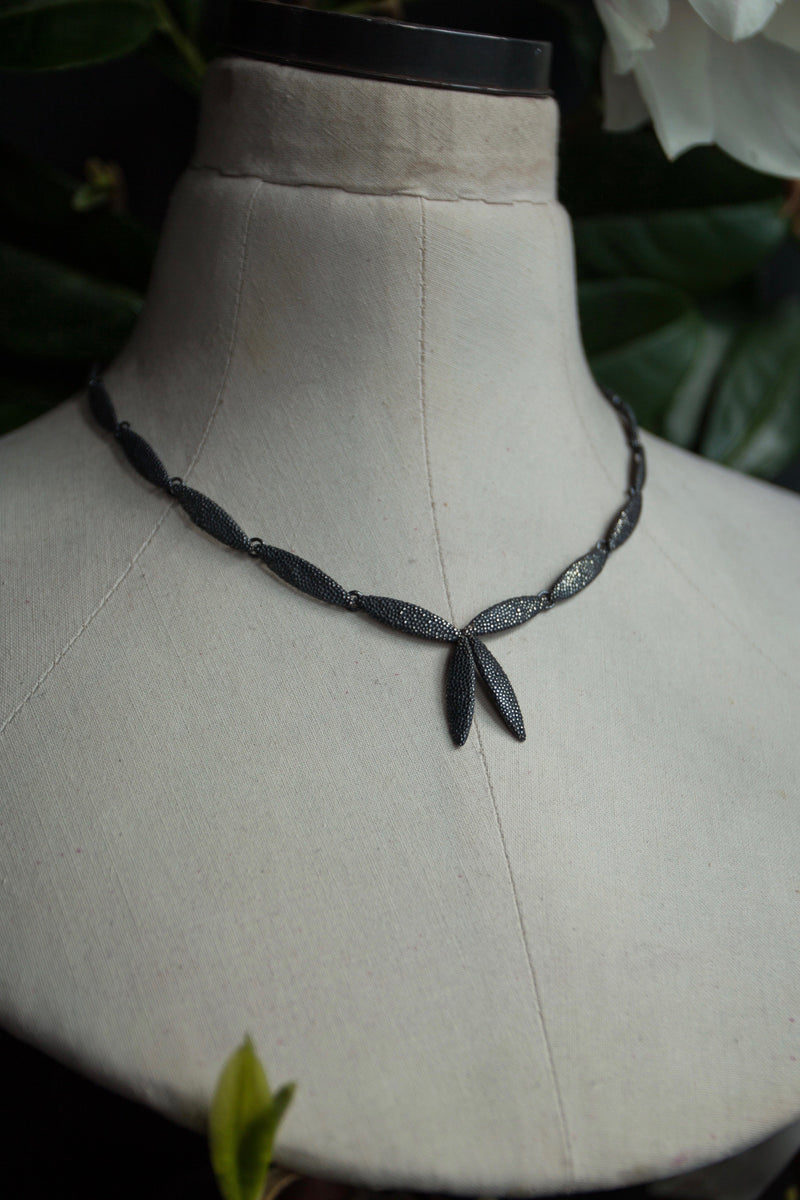 My Petal Necklace in oxidised silver links textured petals into a chain with two petals as a focal point