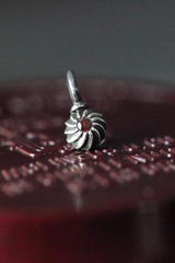 A delicate swirling gemstone charm – choose a red Garnet for your January birthday. 