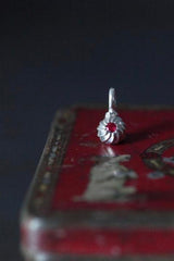 A delicate swirling gemstone charm – choose a Ruby for your July birthday. 