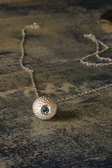 A birthstone pendant for March – a tactile textured ball with a glistening Aquamarine at the base