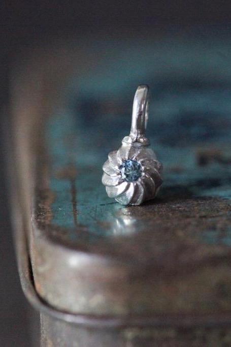 A delicate swirling gemstone charm – choose an Aquamarine for your March birthday. 