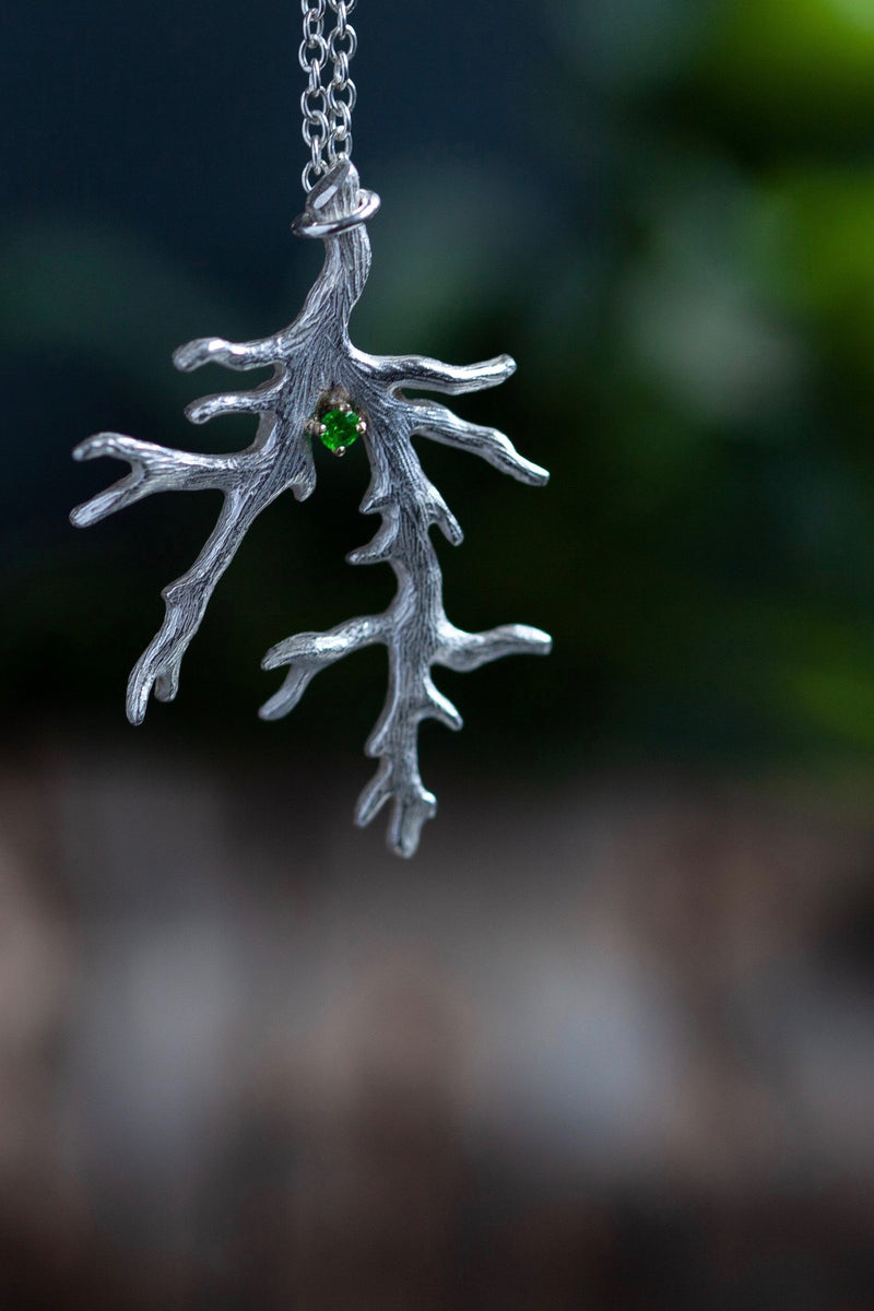 My unusual branch pendant, set with an Emerald, May's birthstone, hangs from a delicate trace chain