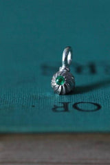 A delicate swirling gemstone charm – choose an Emerald for your May  birthday. 