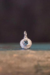 A bobbled pollen charm in silver with a beautiful blue topaz, November's birthstone.