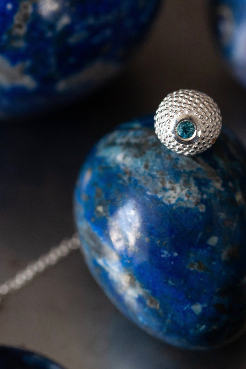 A birthstone pendant for November – a tactile textured ball with a glistening Swiss Blue Topaz at the base