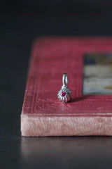 A delicate swirling gemstone charm – choose a pink Tourmaline for your October birthday. 
