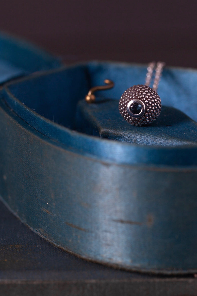 A birthstone pendant for October – a tactile textured ball with a glistening Blue Tourmaline at the base