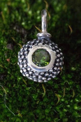 A bobbled pollen charm in oxidised silver with a gorgeous green tourmaline, October's birthstone.