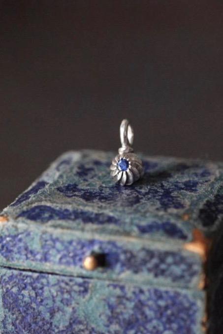 A delicate swirling gemstone charm – choose a Sapphire for your September birthday. 