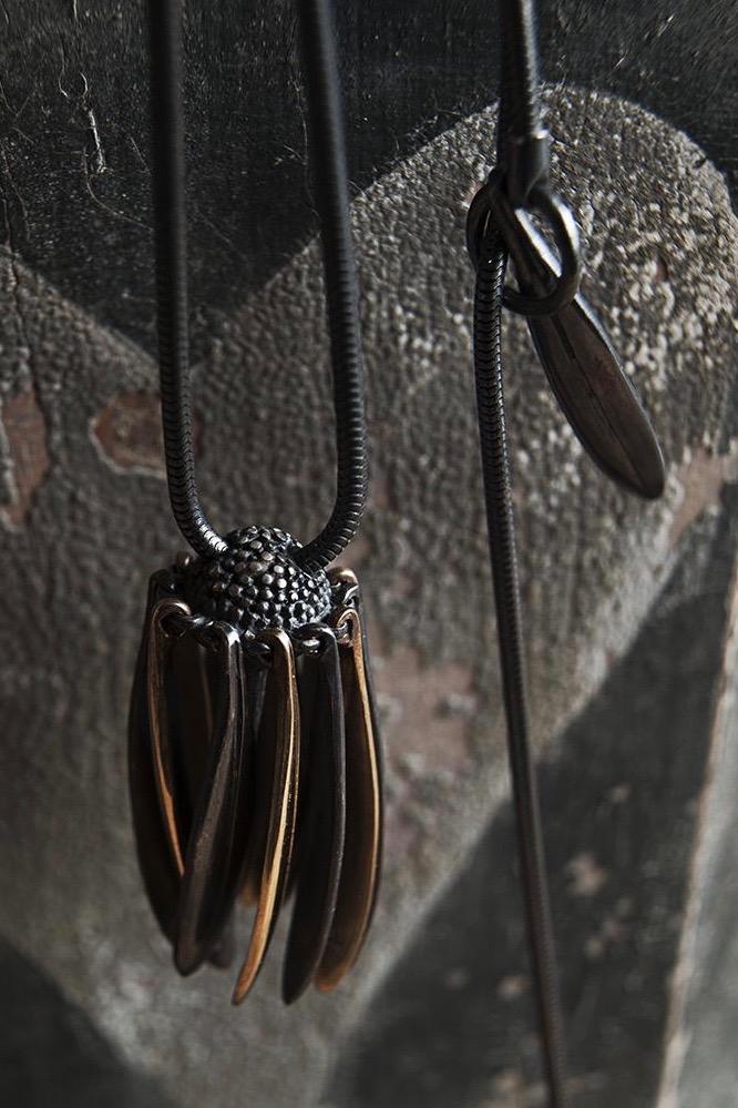 Close up of my Aster Pendant Necklace in oxidised silver and gold is like a tassel with its bobbled head fringed with a series of long elegant flowing petals.