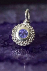 A bobbled pollen charm in silver with a fabulous tanzanite, December's birthstone.